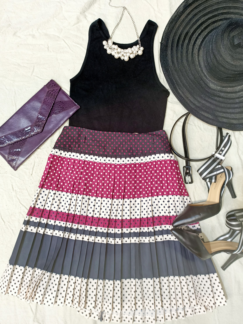 Flat lay of black and pink dress, summer hat, metallic purple clutch purse and black pumps